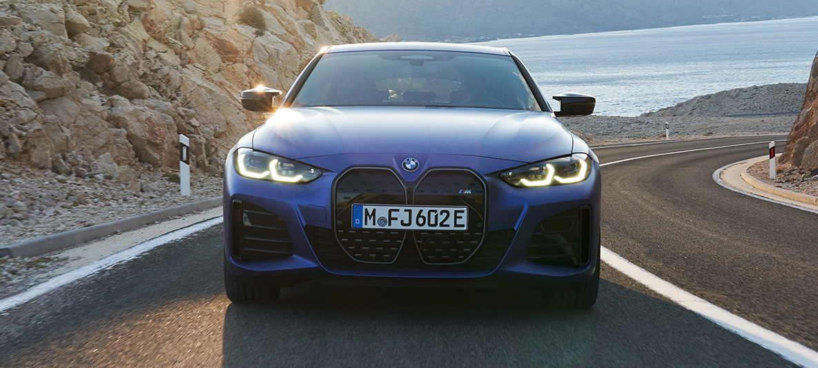BMW i4 M50 G26 2021 sedd framifrån körande BMW i4 M50 G26 2021 M Portimao Blå metallic sedd framifrån körande på väg