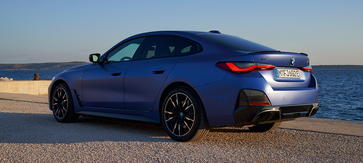 BMW i4 M50 G26 2021 sedd snett bakifrån BMW i4 M50 G26 2021 M Portimao Blå metallic sedd snett bakifrån på kaj