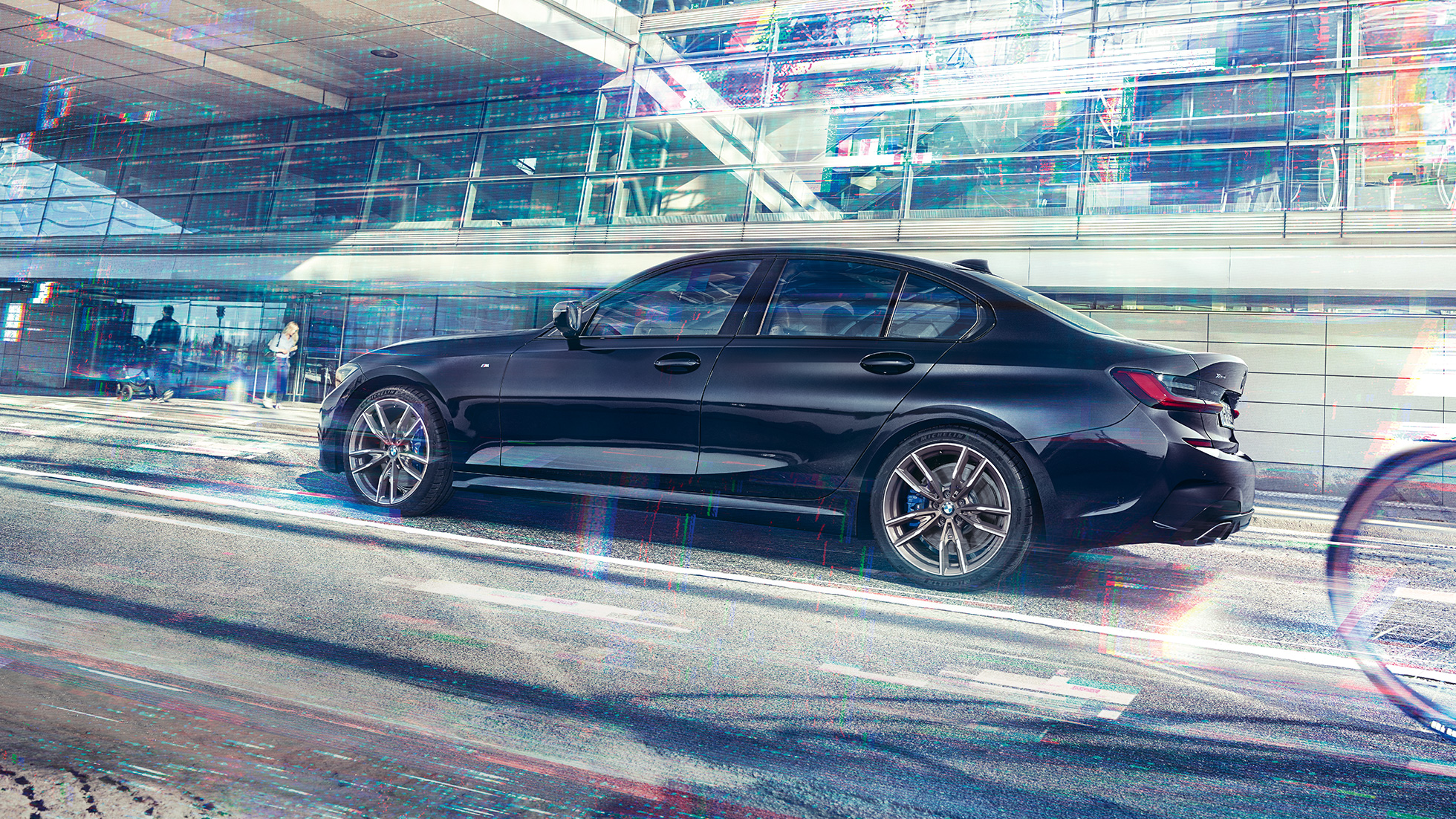 BMW M340i xDrive Sedan sedd från sidan BMW M340i xDrive Sedan G20 Safirsvart metallic sedd från sidan under körning