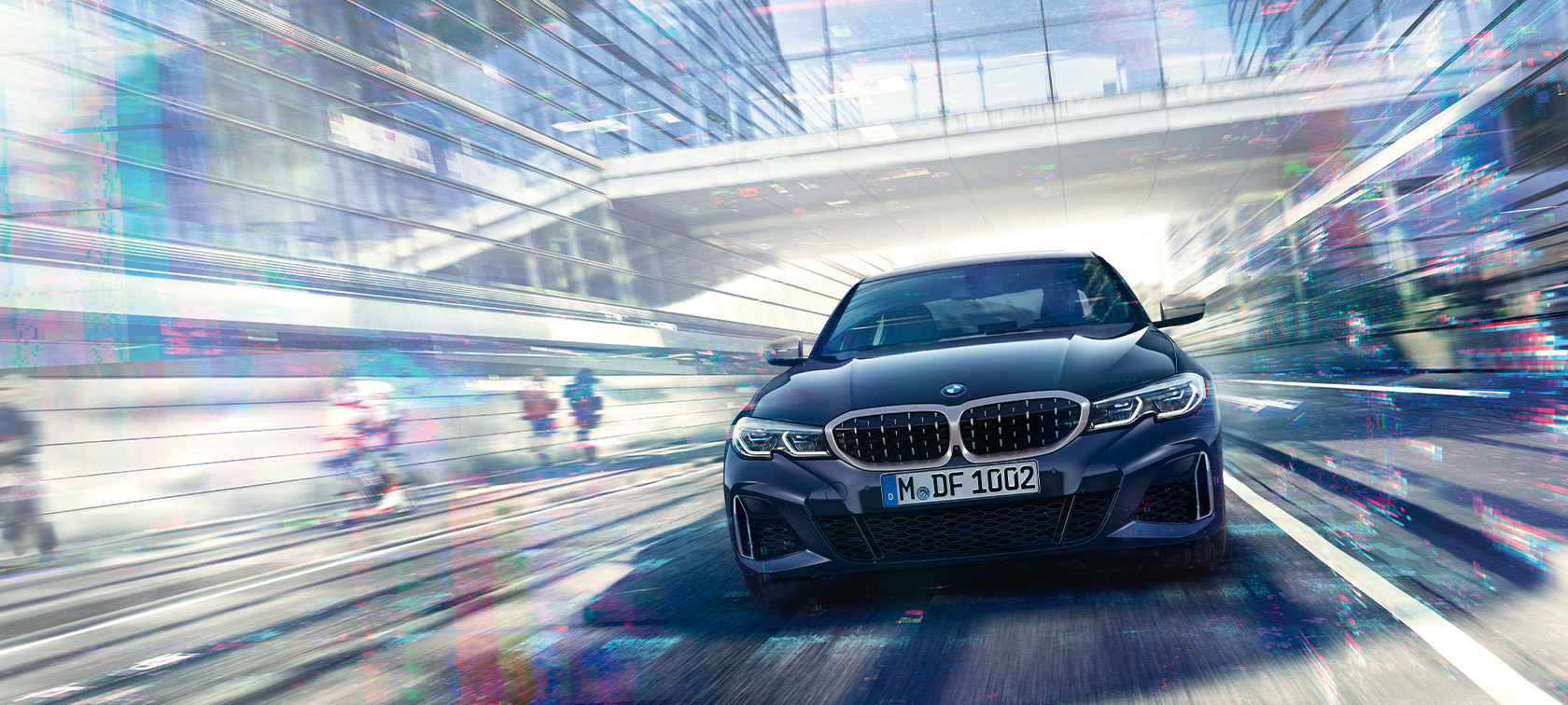 BMW M340i xDrive Sedan sedd framifrån BMW M340i xDrive Sedan G20 Safirsvart metallic sedd framifrån under körning