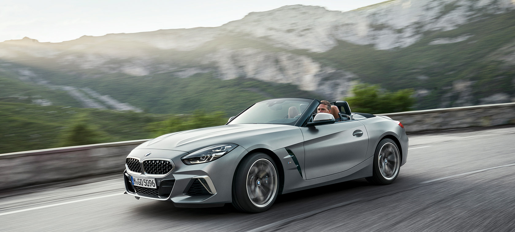 BMW Z4 M40i G29 körandes framför bergkuliss BMW Z4 Roadster M40i G29 2019 Cabriolet BMW Individual Frozen Grey metallic trefjärdedelsvy framifrån körandes framför bergkuliss