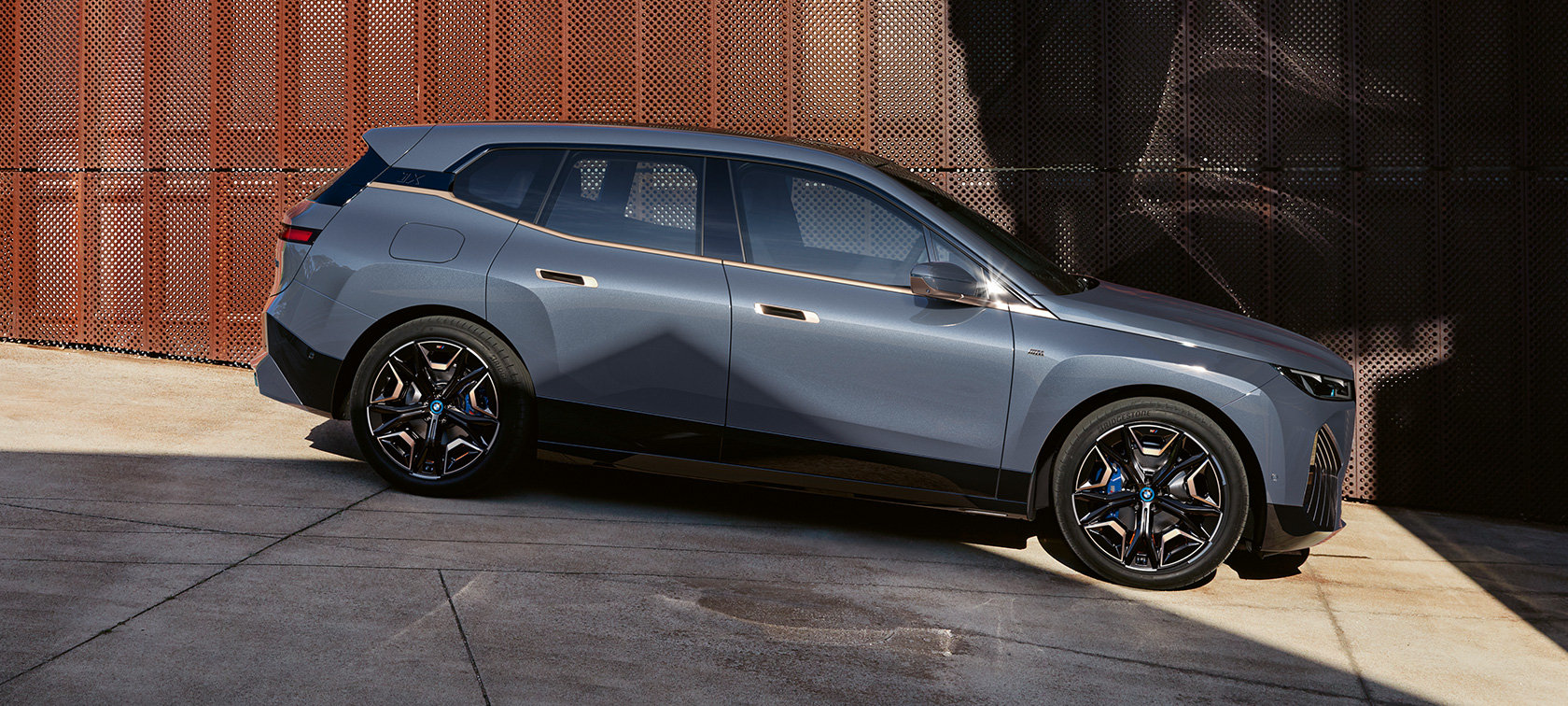 BMW iX M60 i20 2022 eldriven SUV elbil Oxidgrå metallic sedd parkerad från sidan