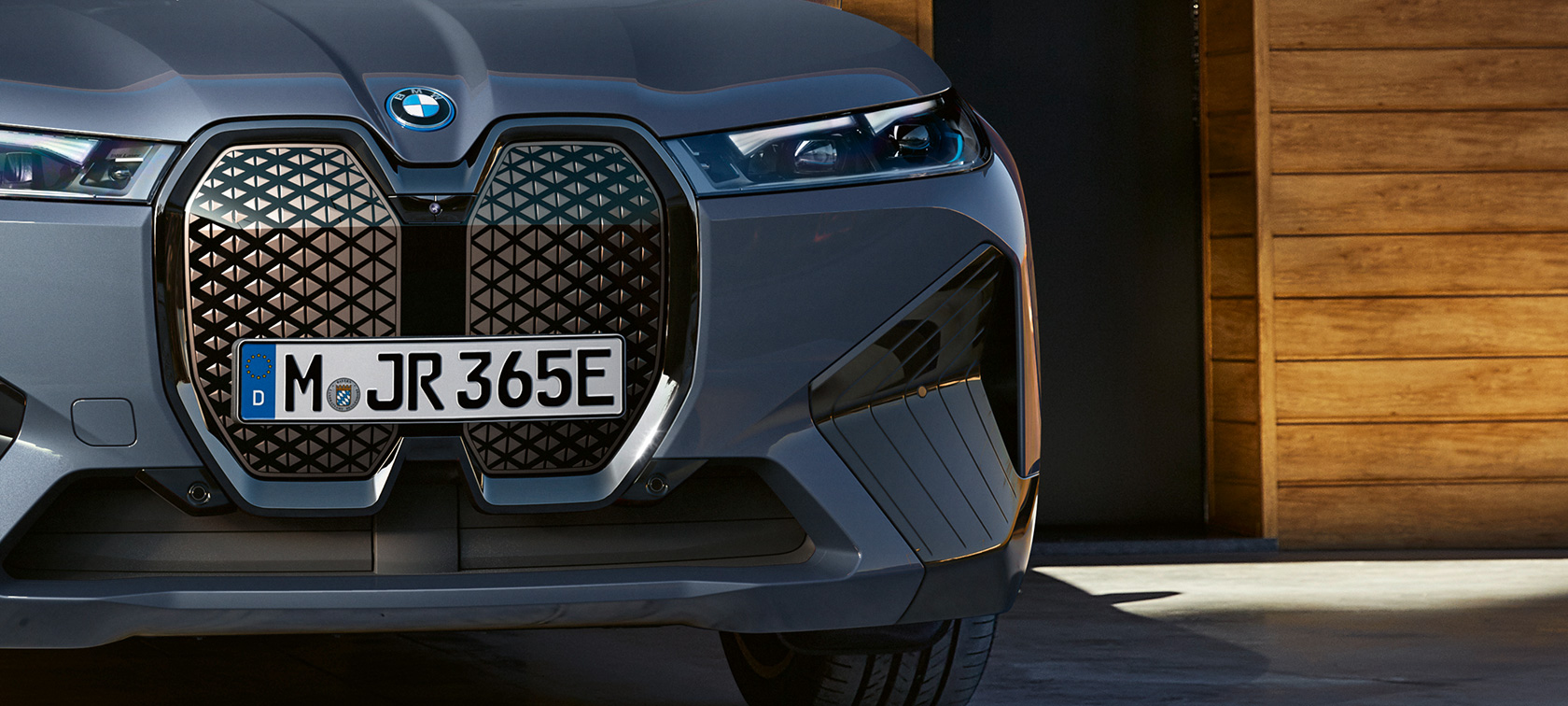 BMW iX M60 i20 2022 eldriven SUV elbil Oxidgrå metallic närbild av frampartiet med vertikal BMW njure