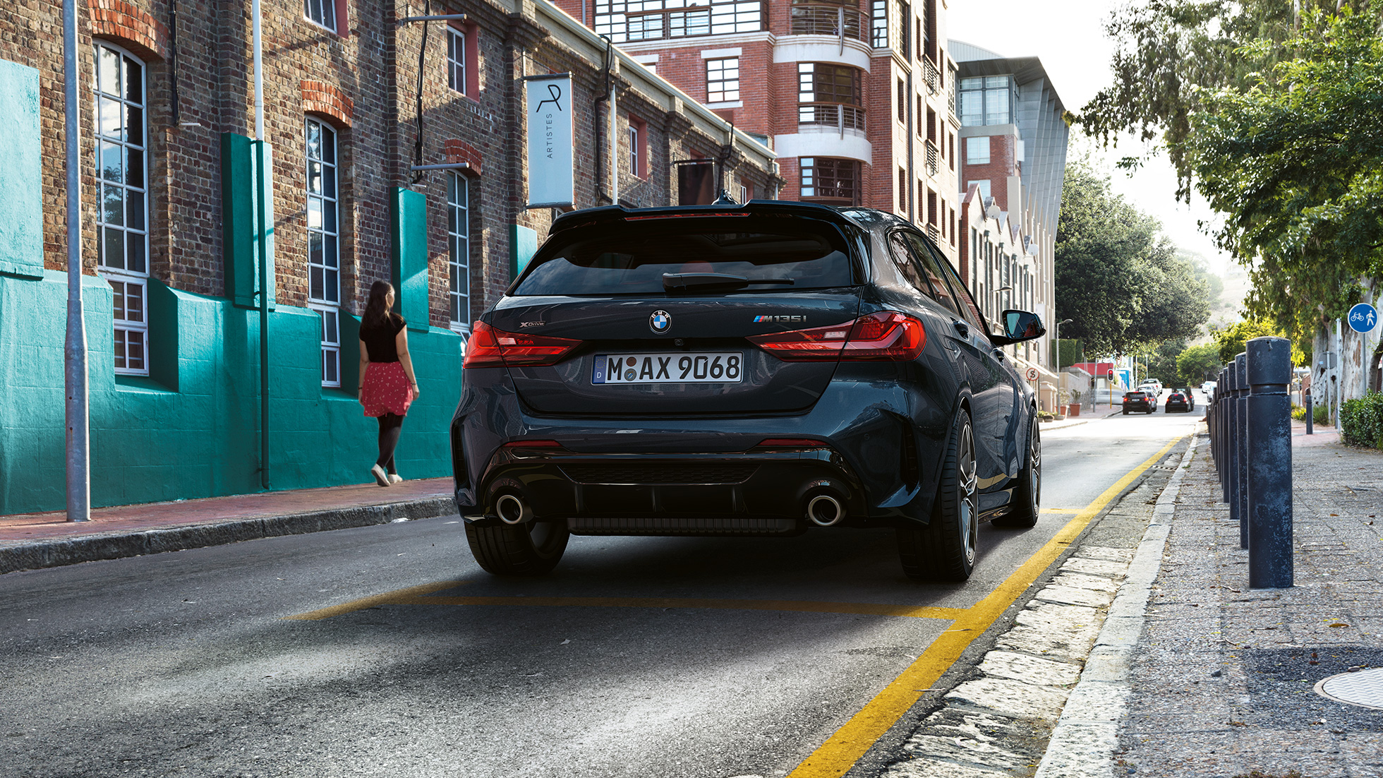 BMW M135i xDrive sedd bakifrån. BMW M135i xDrive i safirsvart metallic, trefjärdelsvy bakifrån, parkerad.