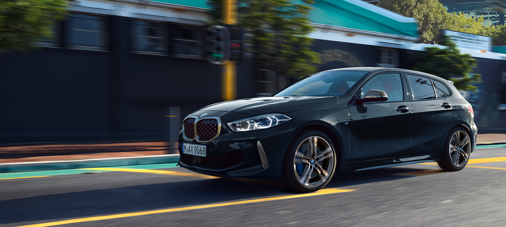 Nya BMW M135i xDrive. Nya BMW M135i xDrive i safirsvart metallic, trefjärdelsvy från sidan, körande.