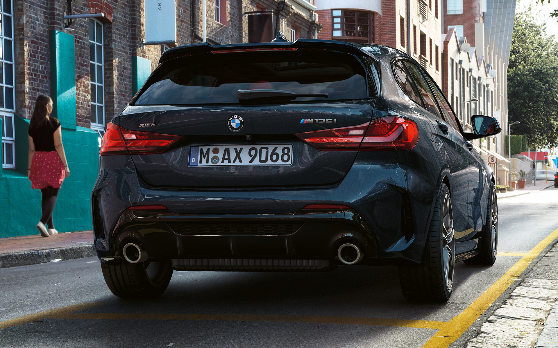 BMW M135i xDrive (F40) i Safirsvart metallic som parkeras sedd bakifrån