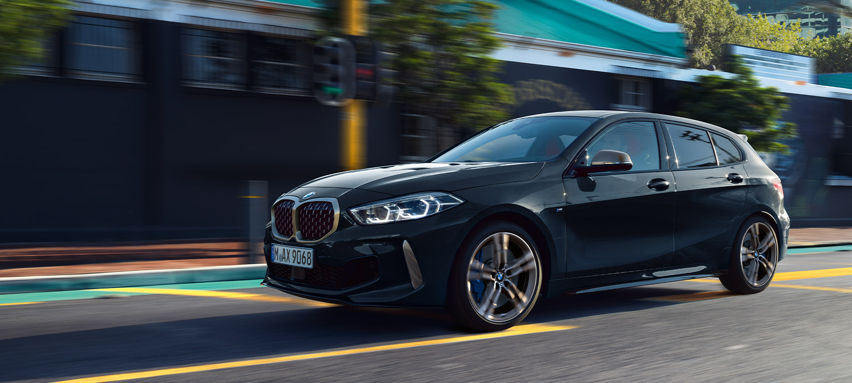 BMW 1-serie M135i xDrive (F40) i Safirsvart metallic som körs i stadsmiljö