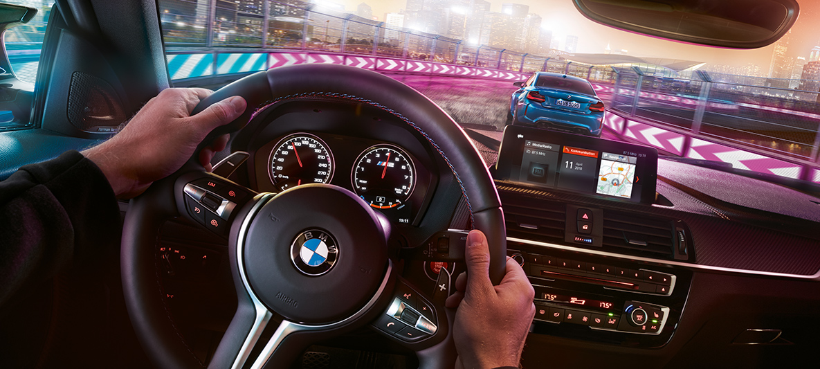 BMW M2 Competition cockpit Två BMW M2 Competition kör racing i mörker, sett inifrån cockpit.