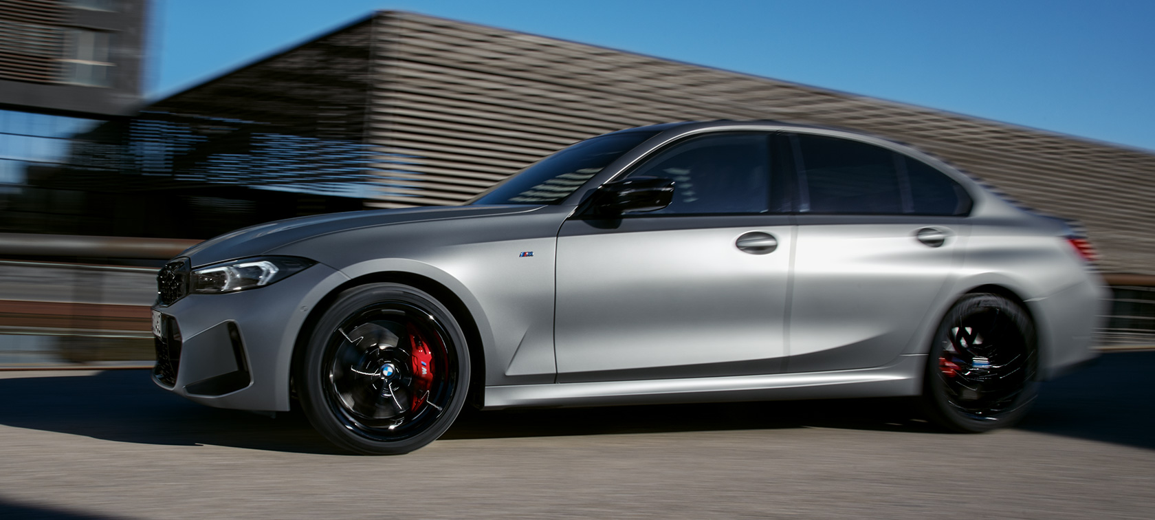 BMW M340i xDrive Sedan sedd från sidan G20 BMW M340i xDrive Sedan G20 BMW Individual Frozen Pure Grey metallic sedd från sidan körandes på en väg