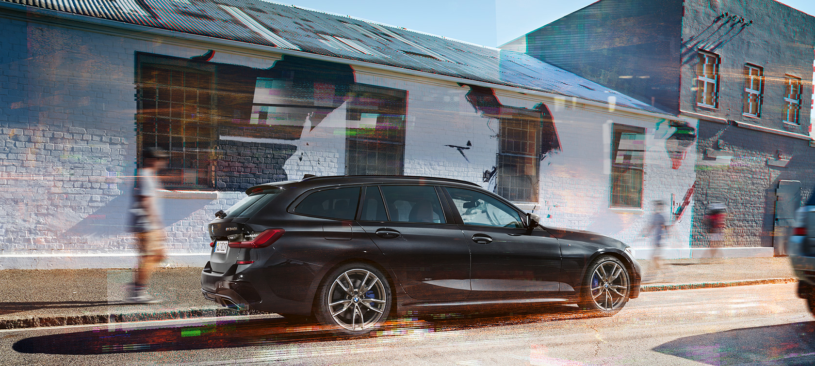 Sidovy BMW M340i xDrive Touring BMW M340i xDrive Touring G21 Black Sapphire metallic sedd från sidan på gata
