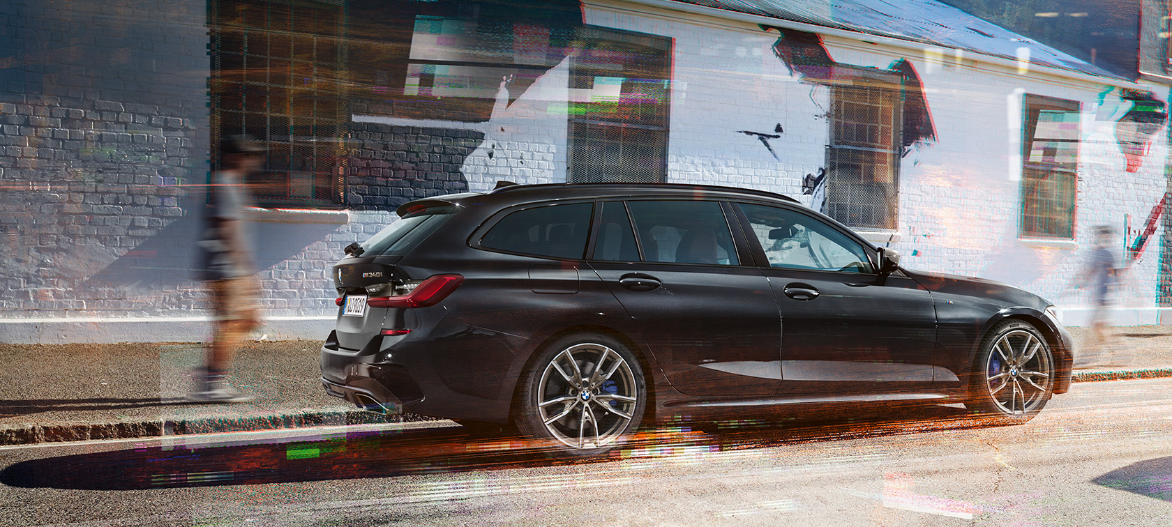 Sidovy BMW M340i xDrive Touring (G21) BMW M340i xDrive Touring (G21) Black Sapphire metallic sedd från sidan på gata