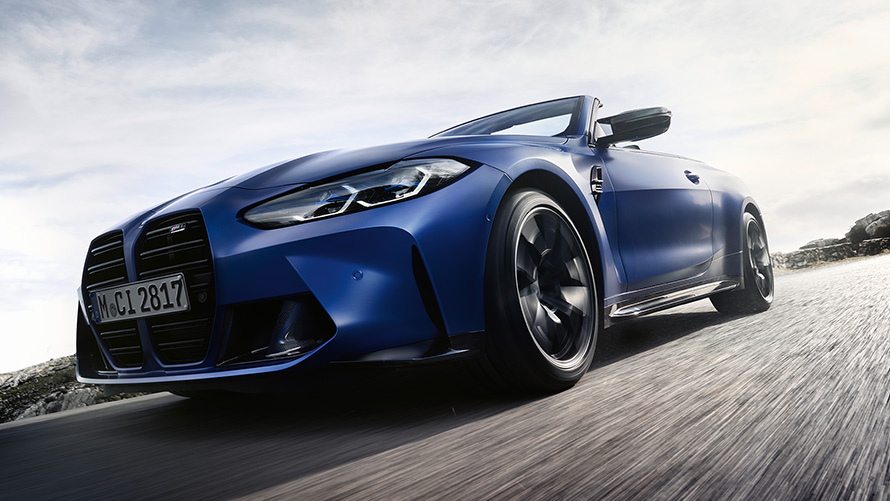BMW M4 Competition Cabriolet med M xDrive G83 2021 sedd framifrån med dubbelnjure BMW M4 Competition Cabriolet med M xDrive G83 2021 BMW Individual Frozen Portimao Blå metallic Front med njurar ur grodperspektiv