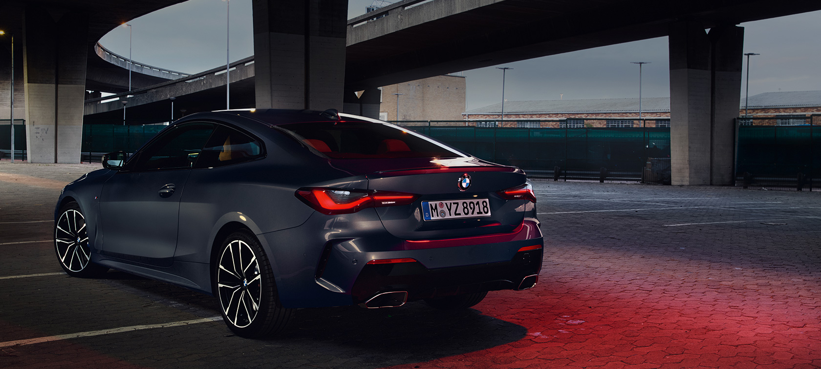 Trefjärdelsvy bakifrån BMW M440i xDrive Coupé G22 2020 BMW M440i xDrive Coupé Dravitgrå metallic G22 2020 sedd snett bakifrån