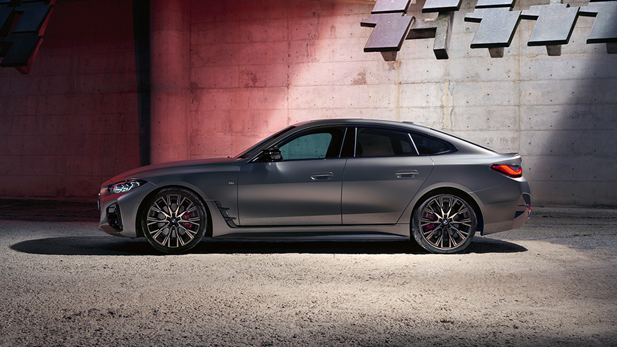 BMW M440i xDrive Gran Coupé G26 2021 sedd från sidan BMW M440i xDrive Gran Coupé G26 2021 Frozen Pure Grey metallic sedd från sidan framför vägg