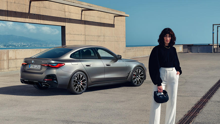 BMW M440i xDrive Gran Coupé G26 2021 sedd snett bakifrån med modell BMW M440i xDrive Gran Coupé G26 2021 sedd snett bakifrån med modell