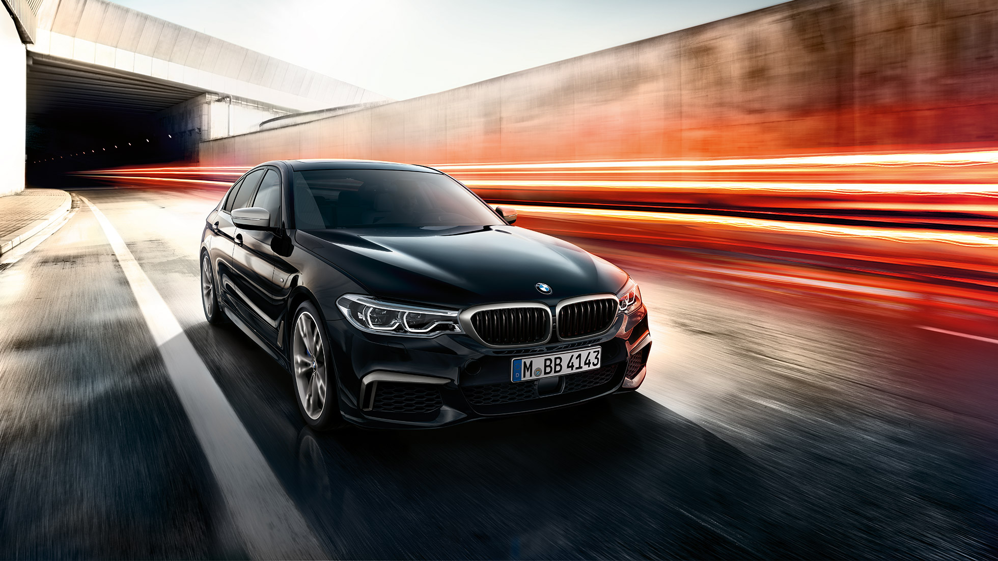 BMW M550i och BMW M550d. BMW M550i och BMW M550d trefjärdedelsvy framifrån av bilen i aktion.
