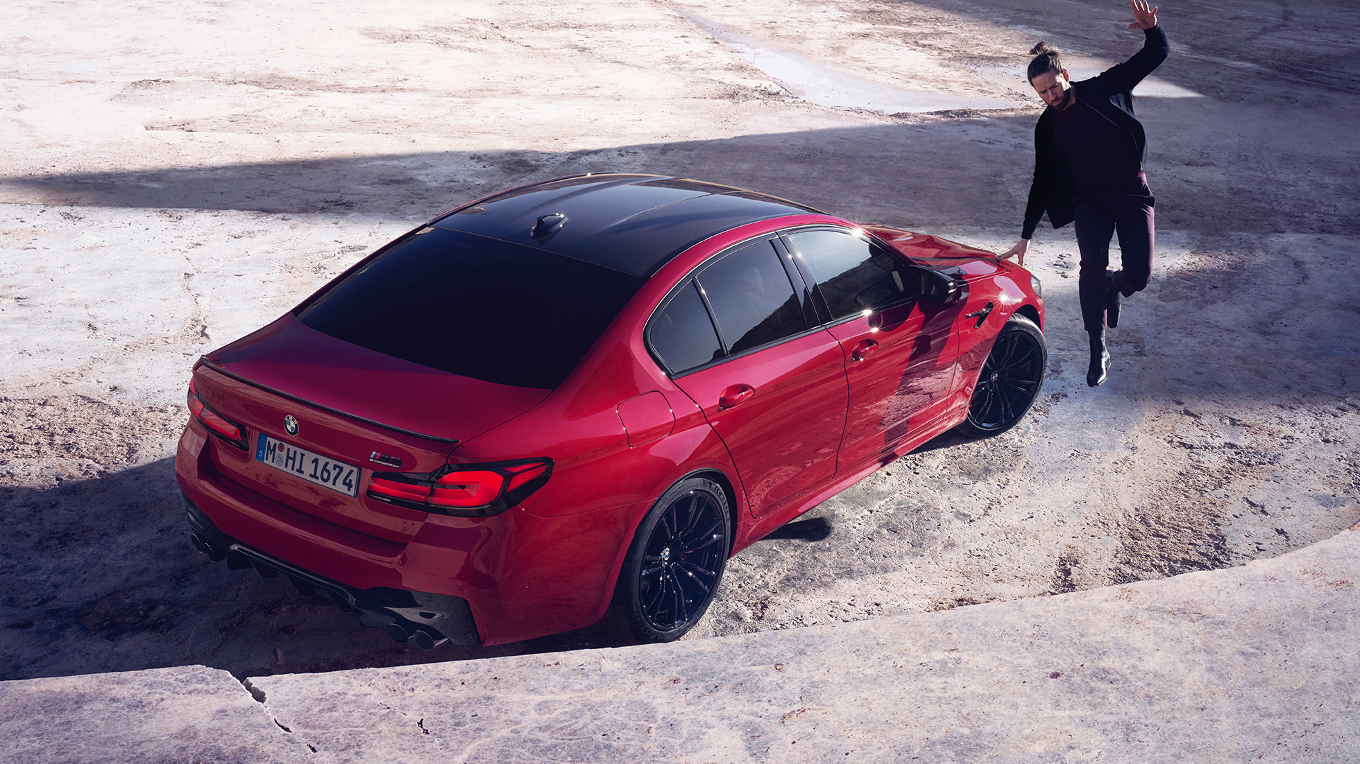 BMW M5 Competition F90 LCI Facelift 2020 sedd i aktion snett bakifrån ur fågelperspektiv BMW M5 Competition F90 LCI Facelift 2020 BMW Individual Imola Röd sedd snett bakifrån ur fågelperspektiv