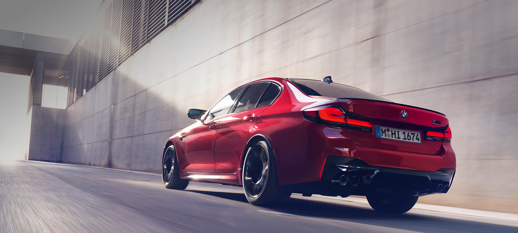 BMW M5 Competition F90 LCI Facelift 2020 sedd i aktion snett bakifrån BMW M5 Competition F90 LCI Facelift 2020 BMW Individual Imola Röd sedd snett bakifrån