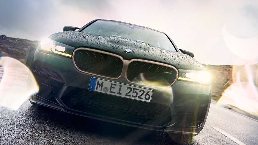 BMW M5 CS F90 2021 Frozen Deep Green metallic framifrån med tända strålkastare