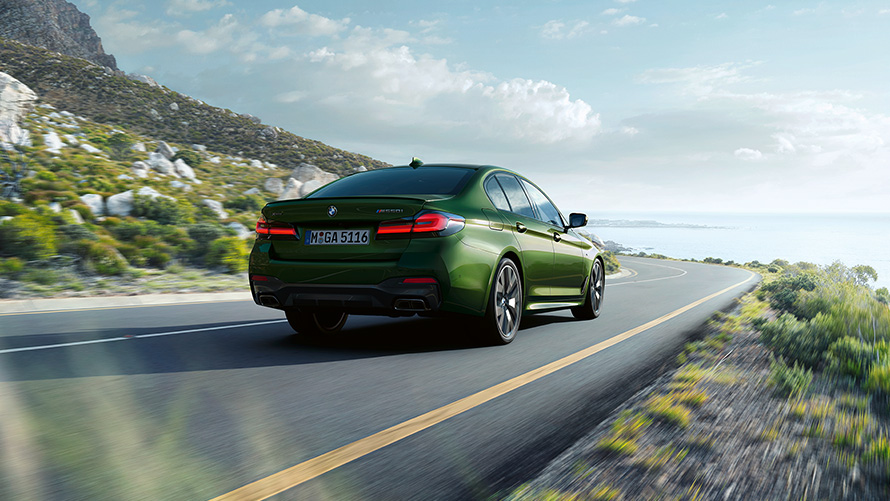 BMW M550i xDrive Sedan G30 LCI Facelift 2020 BMW Individual Verde Ermes metallic sedd i aktion snett bakifrån