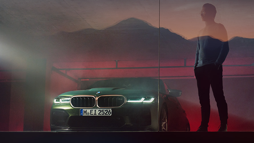 BMW M5 CS F90 2021 framifrån med man BMW M5 CS F90 2021 Frozen Deep Green metallic framifrån med man