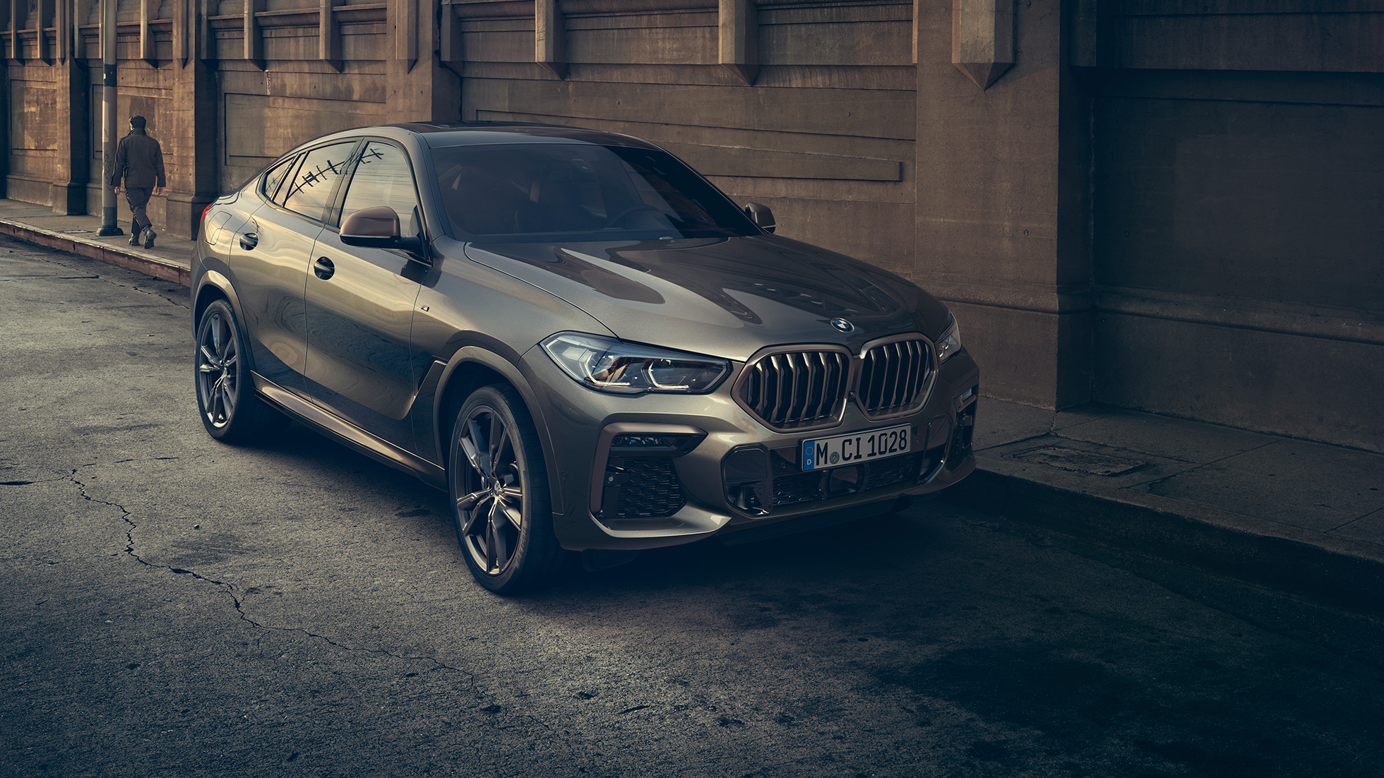 BMW X6 M50i parkerad. BMW X6, trefjärdedelsvy framifrån, parkerad framför stadsmiljö.