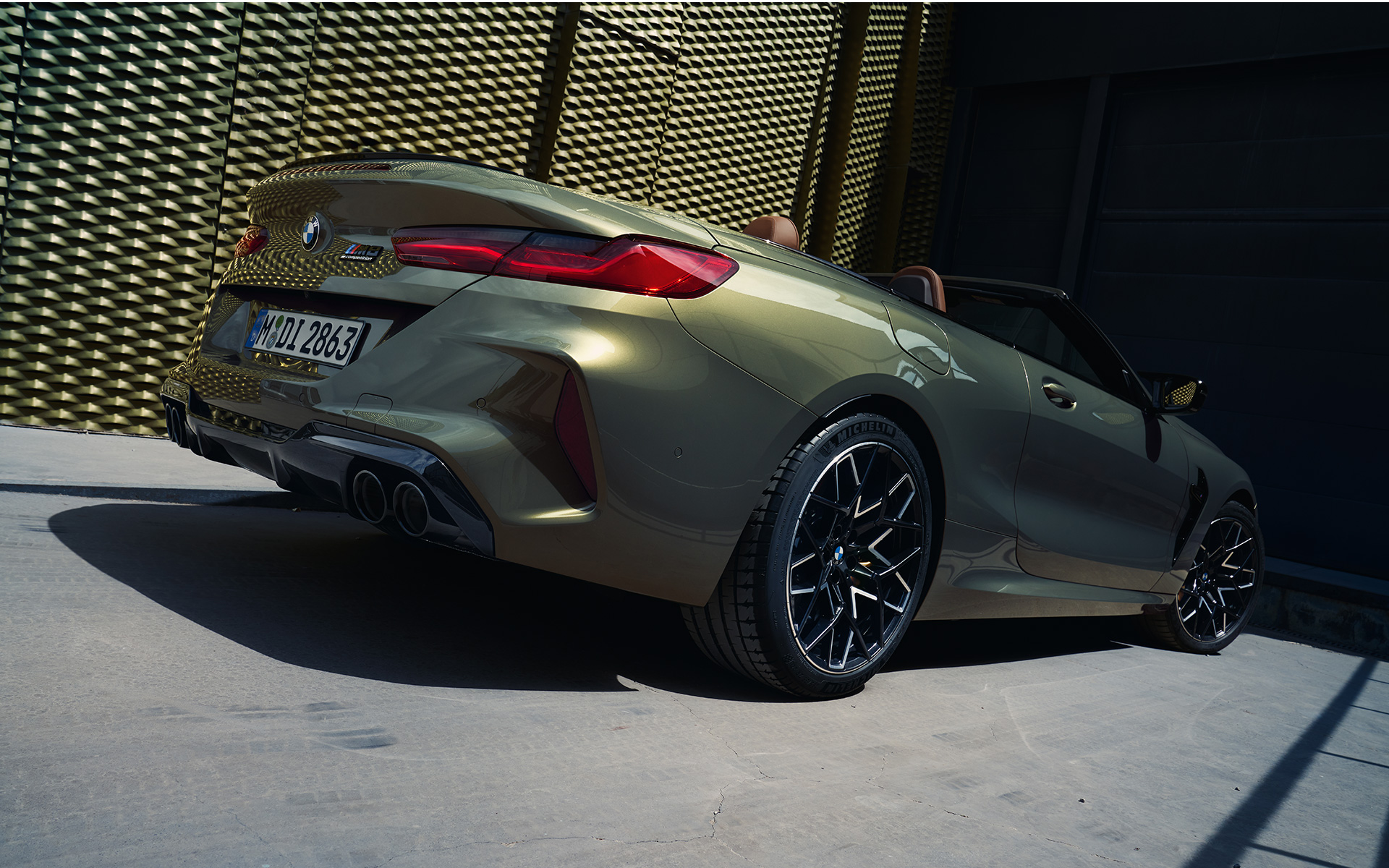Snett bakifrån BMW M8 Competition Cabriolet F91 LCI Facelift 2022 BMW M8 Competition Convertible F91 LCI Facelift 2022 BMW Individual Brass metallic three-quarter rear view low angle shot