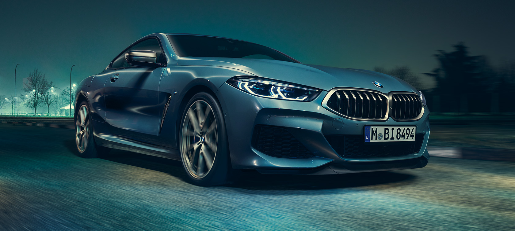 BMW M850i xDrive Coupé, trefjärdedelsvy framifrån. BMW M850i xDrive Coupé i Barcelona Blåmetallic, körande, trefjärdedelsvy framifrån.