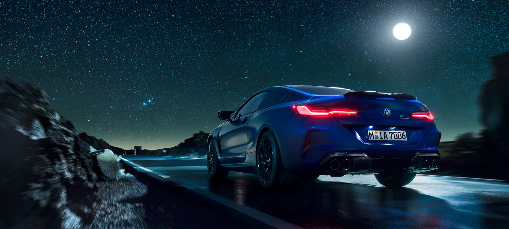 BMW M8 Competition Coupé, sedd bakifrån, körandes i natten i fullmånens sken.