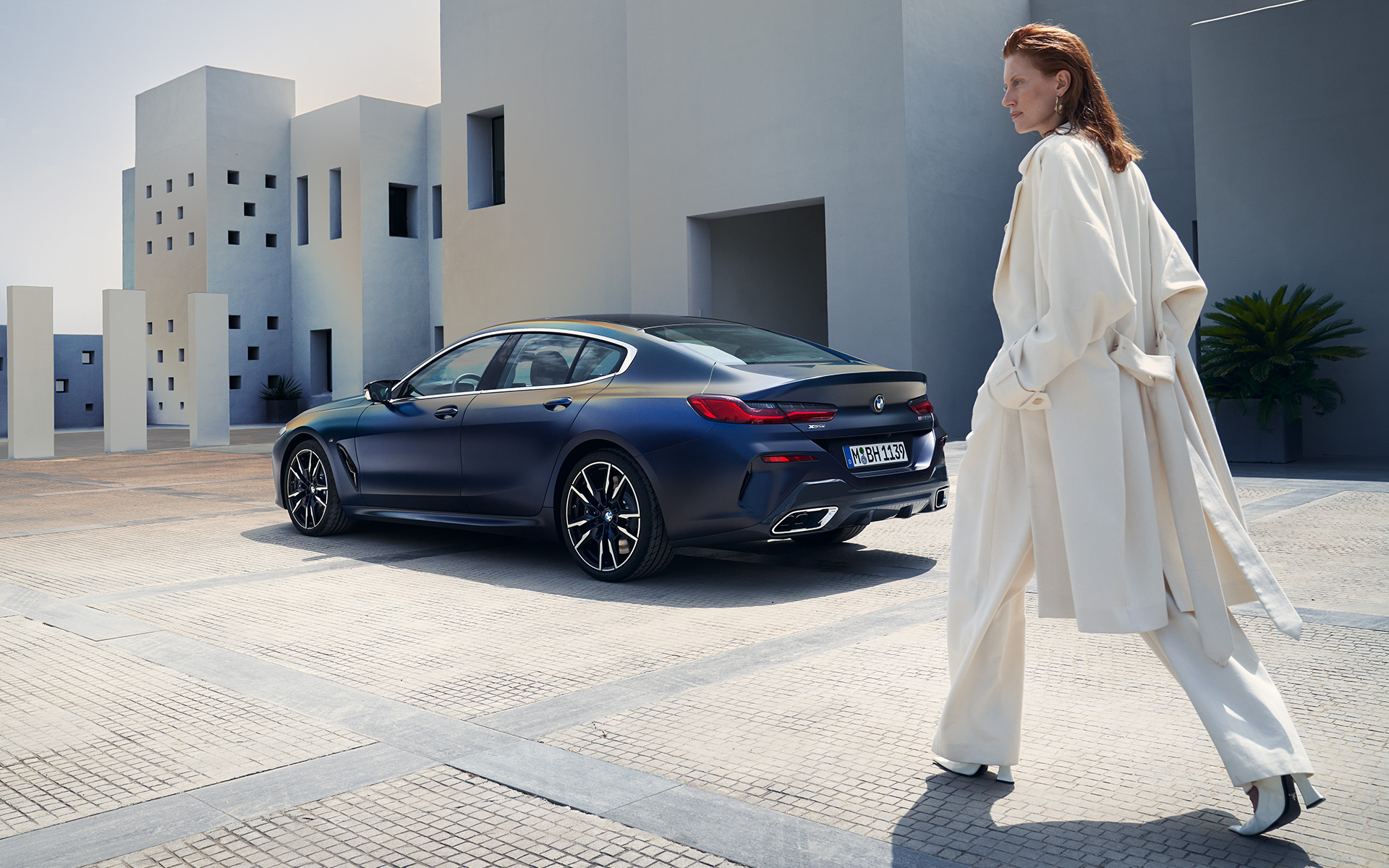 BMW M850i xDrive Gran Coupé G16 LCI Facelift 2022 sidvy med kvinnlig modell BMW M850i xDrive Gran Coupé G16 LCI Facelift 2022 sidvy med kvinnlig modell