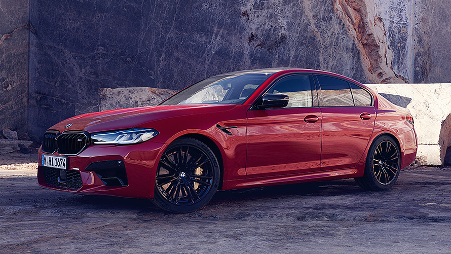 BMW M5 F90 sedd snett framifrån körande på väg BMW M-modeller BMW M5 F90 sedd snett framifrån körande på väg