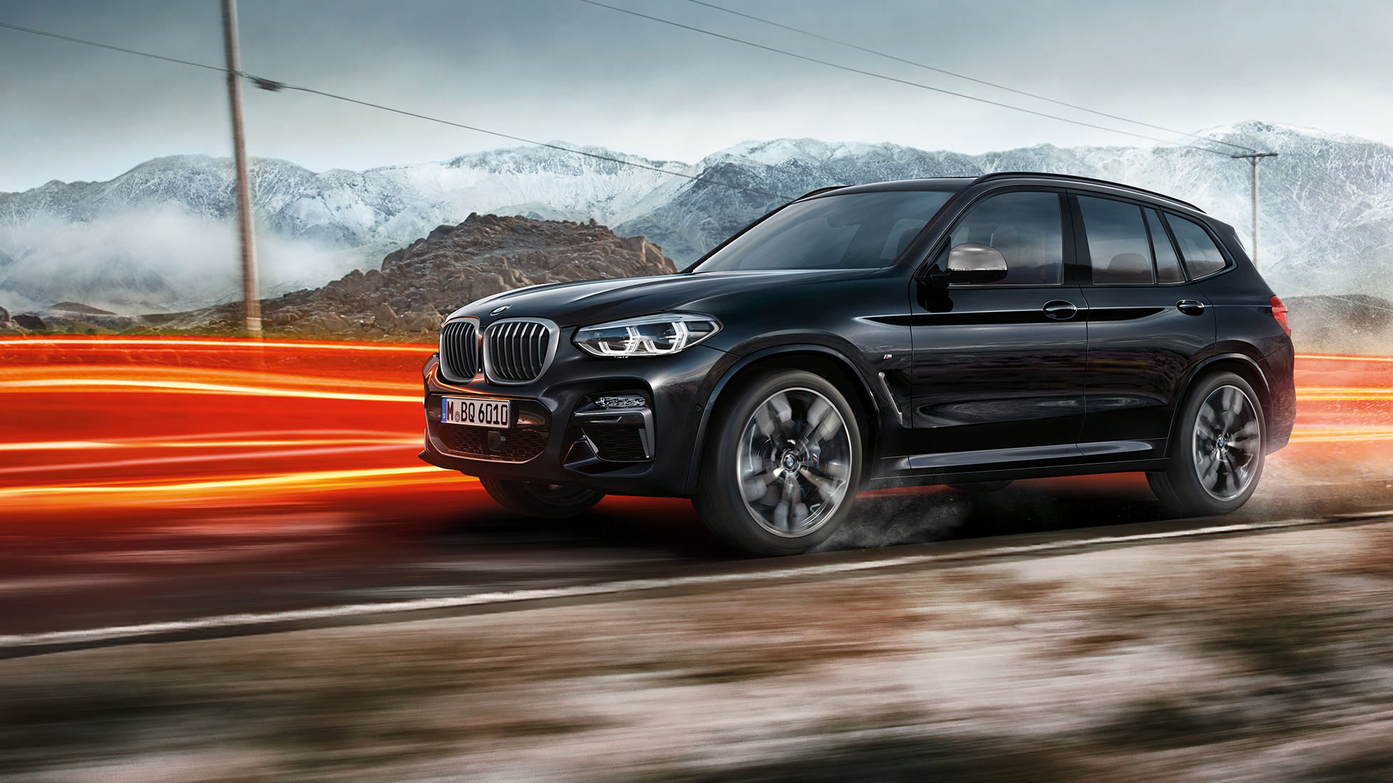 BMW X3 M40i och BMW X3 M40d, vy från sidan. BMW X3 M40i och BMW X3 M40d i Safirsvart metallic, kommer körande, Exteriör, vy från sidan berglandskap med ljusstrimmor.