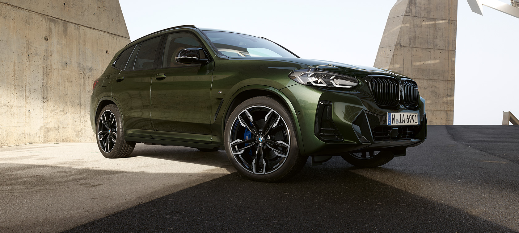BMW X3 M40i G01 LCI Facelift sedd snett framifrån parkerad BMW X3 M40i G01 LCI Facelift 2021 Malakitgrön metallic sedd snett framifrån parkerad