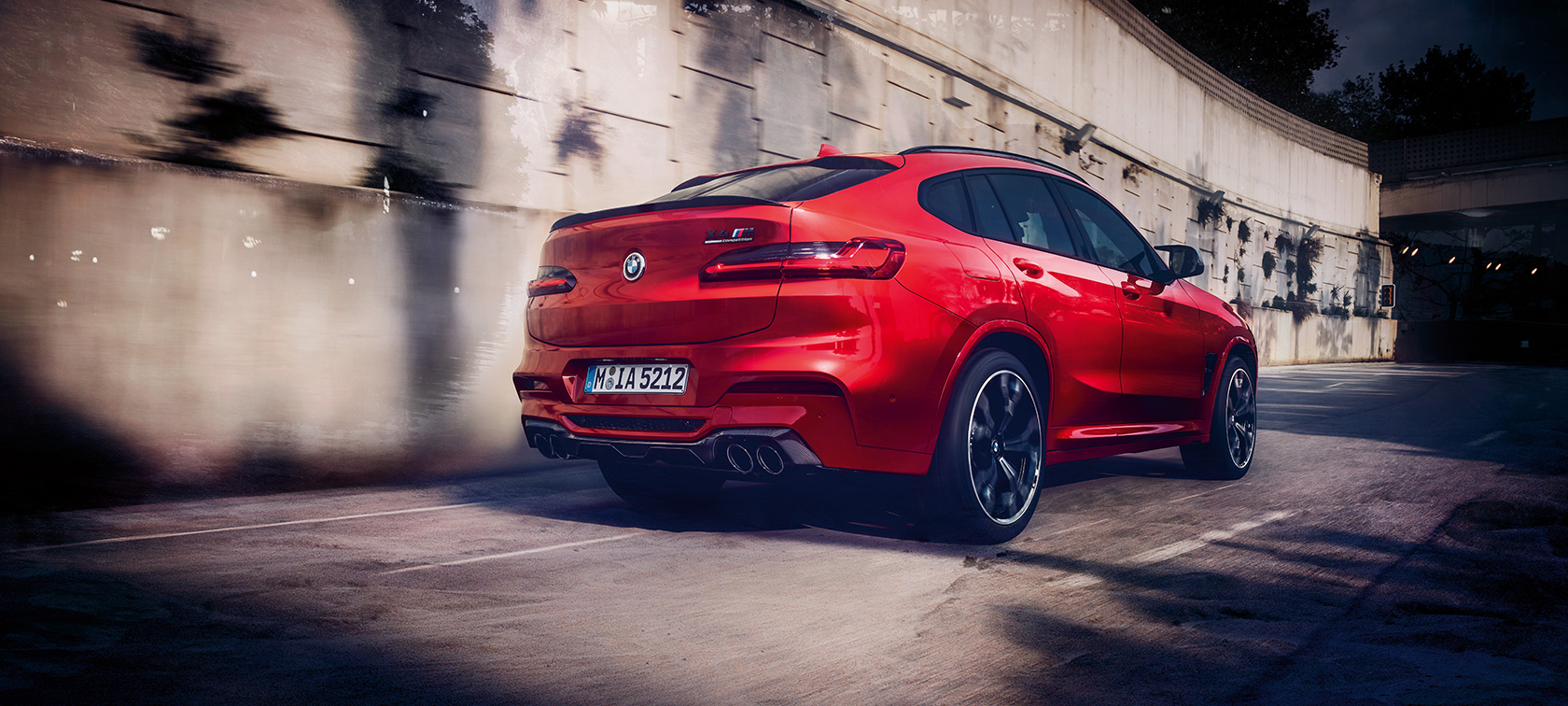 BMW X4 M Competition, Trefjärdedels vy bakifrån. BMW X4 M Competition i Torontoröd metallic, kommer körande, Exteriör, Trefjärdedels vy bakifrån.