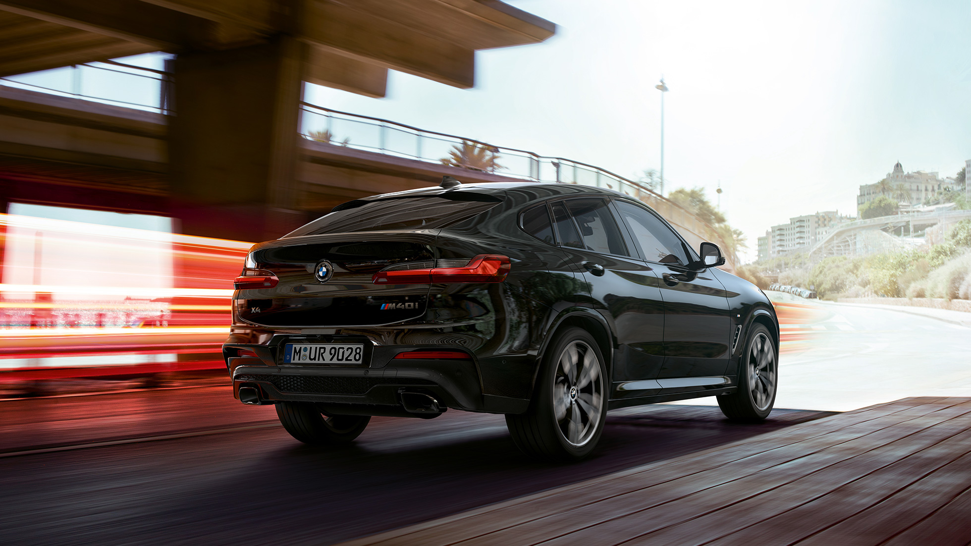 BMW X4 M40i, Trefjärdedels vy framifrån. BMW X4 M40i i Safirsvart metallic, kommer körande, Exteriör, trefjärdedels vy framifrån med ljusstrimmor.
