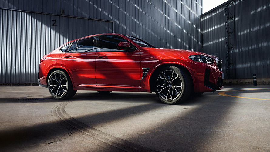 BMW X4 M F98 LCI Facelift 2021 Torontoröd metallic sedd från sidan framför fabriksbyggnad