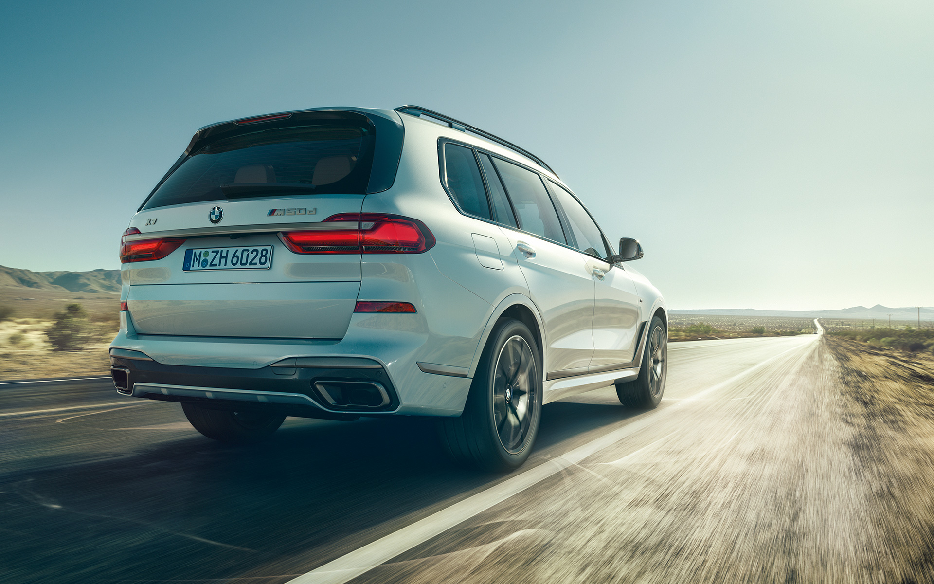 BMW X7 M50d G07 2019 mineralvit, bakifrån under körning BMW X7 M50d G07 2019 mineralvit, bakifrån under körning