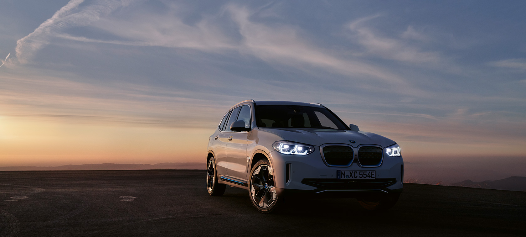 BMW iX3 G08 Utföranden sedd snett framifrån BMW iX3 G08 2020 Mineralvit metallic sedd snett framifrån i kvällsljus