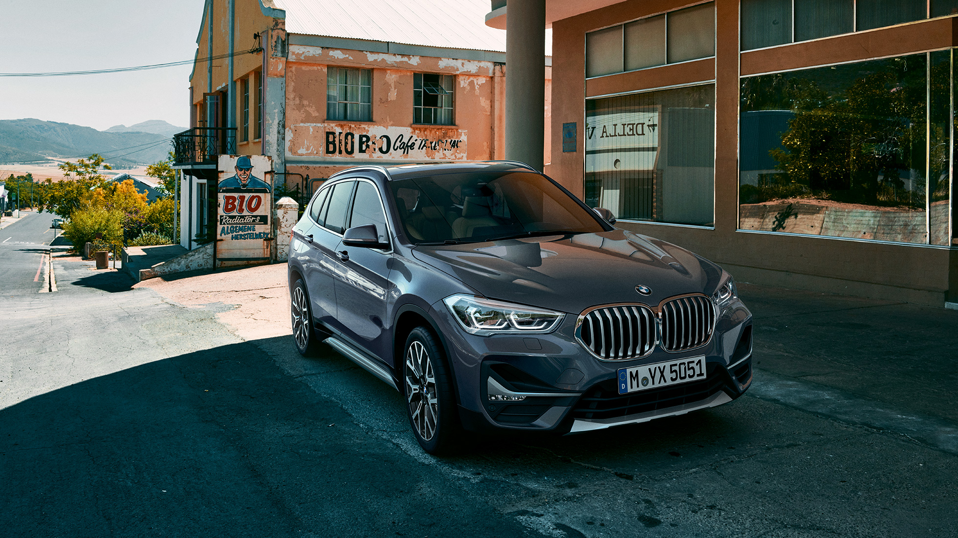 BMW X1, trefjärdedelsvy framifrån. BMW X1, trefjärdedelsvy framifrån, parkerad framför stadsmiljö.