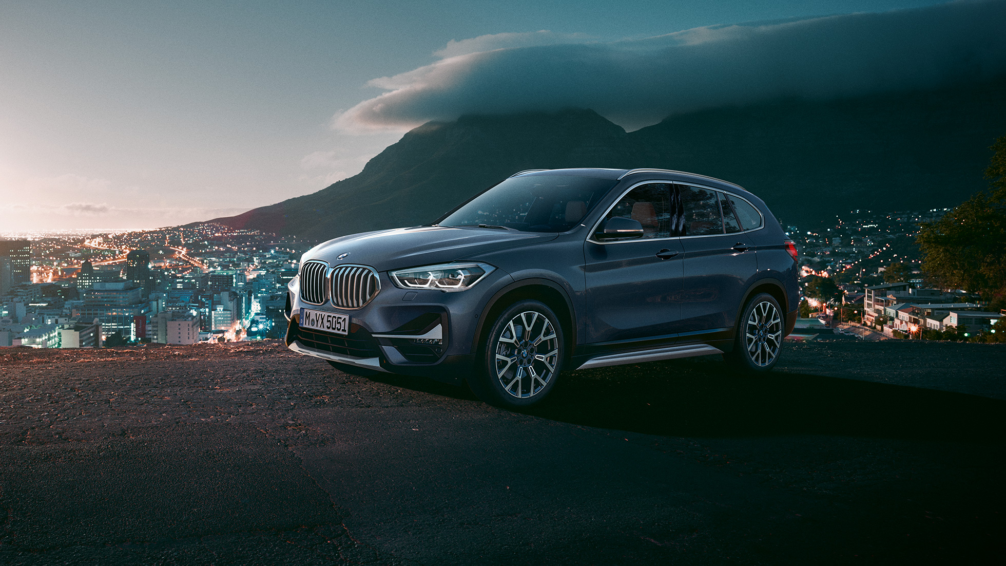 BMW X1, trefjärdedelsvy från sidan. BMW X1, trefjärdedelsvy från sidan, parkerad framför stadsmiljö.