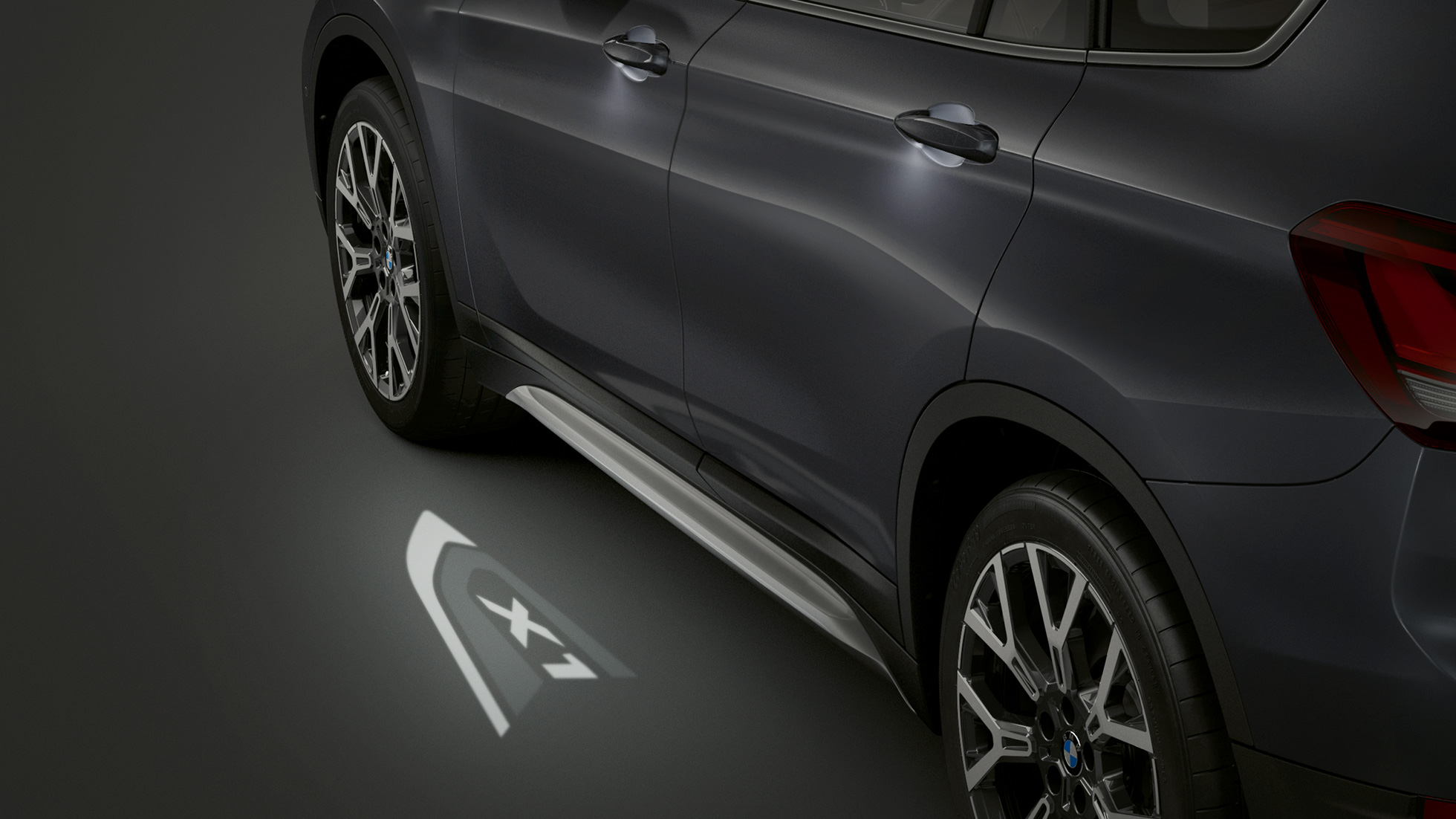 BMW X1, LED-projicering “X1”. BMW X1, sedd från sidan med LED-projicering “X1” i fokus.