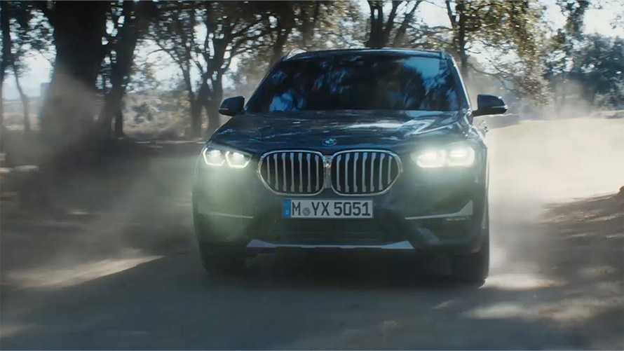 BMW X1 F48 LCI sedd snett framifrån BMW X1 F48 LCI sedd snett framifrån, körandes framför ett naturlandskap