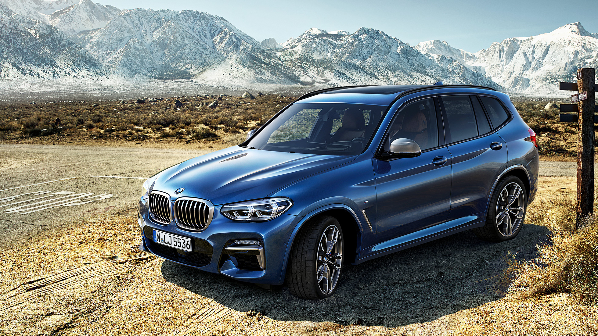 BMW X3 M40i, trefjärdedelsvy framifrån i bergen BMW X3 M40i, trefjärdedelsvy framifrån i bergen