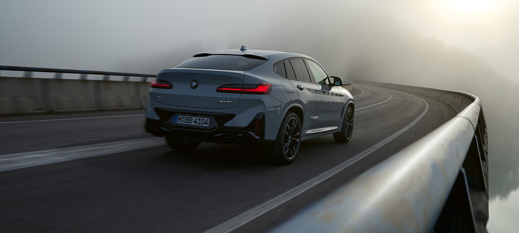 BMW X4 G02 BMW Originaltillbehör 2021 BMW X4 G02 BMW originaltillbehör Brooklyn-grå sedd snett bakifrån körandes 2021