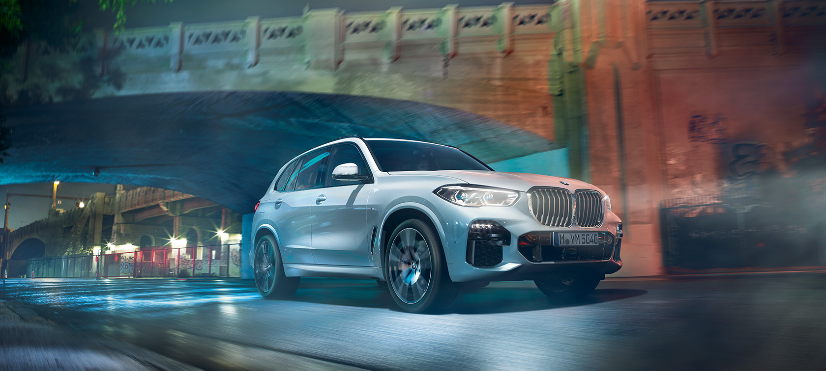 BMW X5 G05 2021 Mineralvit metallic sedd snett framifrån körandes på natten