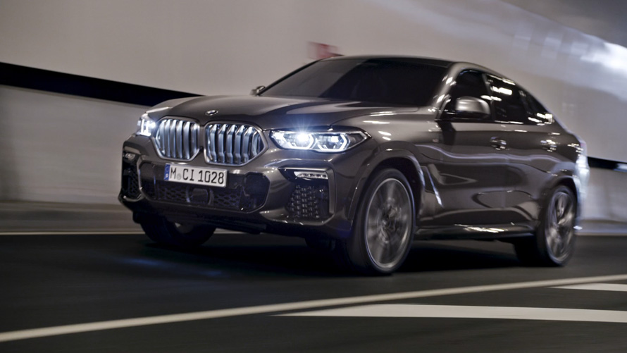 BMW X6 G06 2019 sedd snett framifrån BMW X6 G06 2019, sedd snett framifrån körandes med stad i bakgrunden