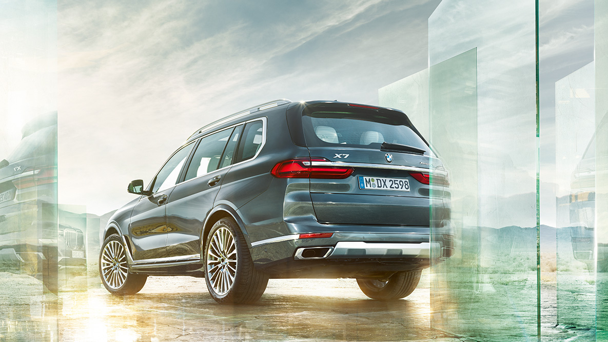 BMW X7, körkomfort och kördynamik BMW X7 snett bakifrån framför en abstrakt bakgrund