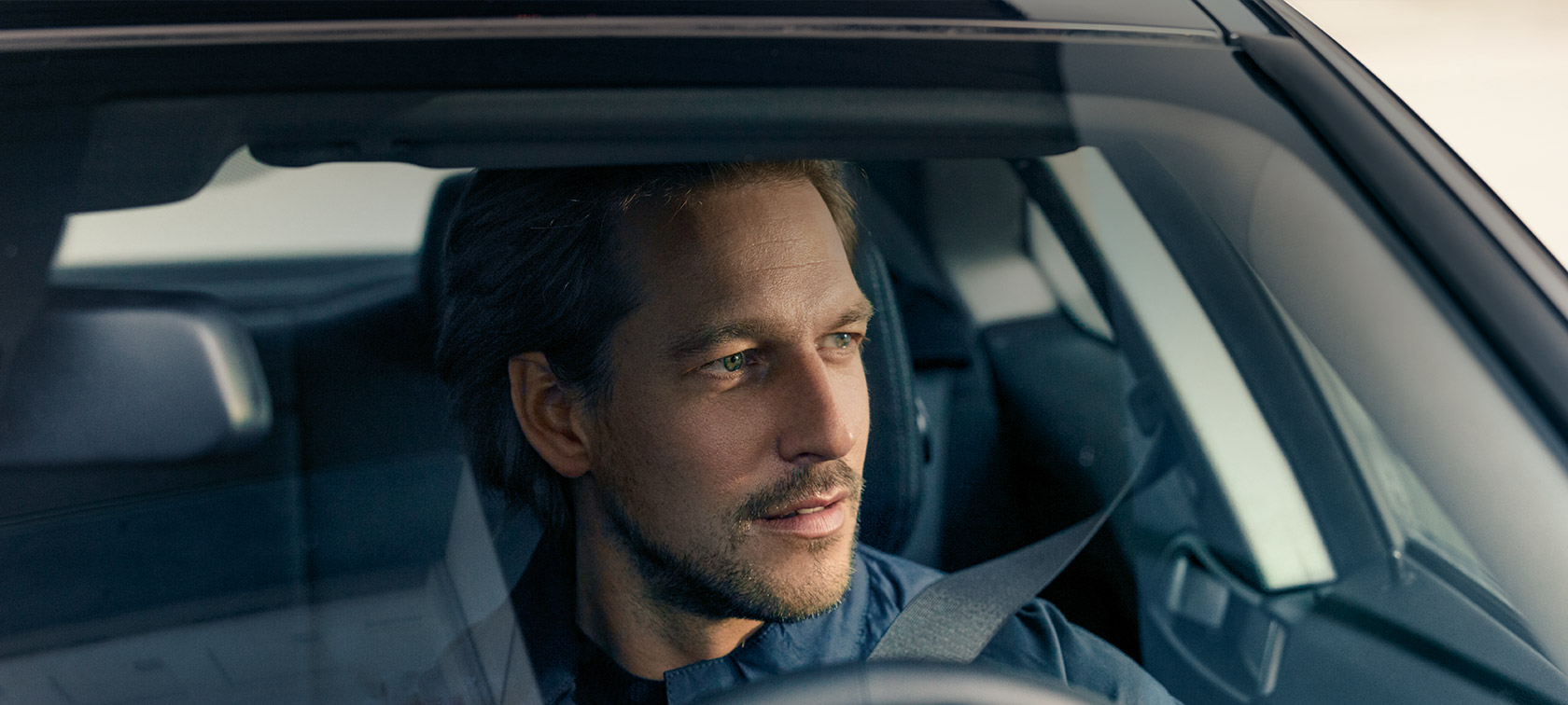 BMW Service Inclusive en man framför en BMW i4 vid kusten