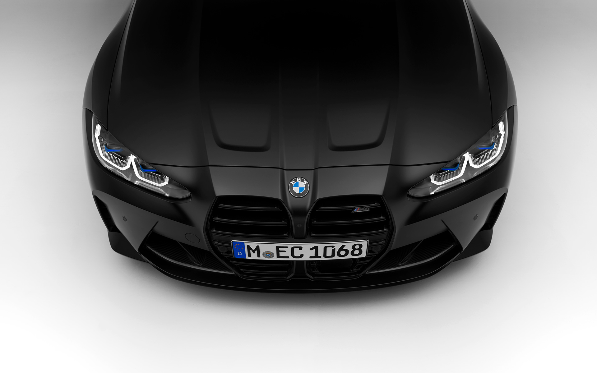 BMW M4 Competition coupé G82 2021 BMW Individual Frozen Black metallic, sedd framifrån BMW M4 Competition coupé G82 2021 BMW Individual Frozen Black metallic stillastående sedd framifrån, sektion sedd uppifrån