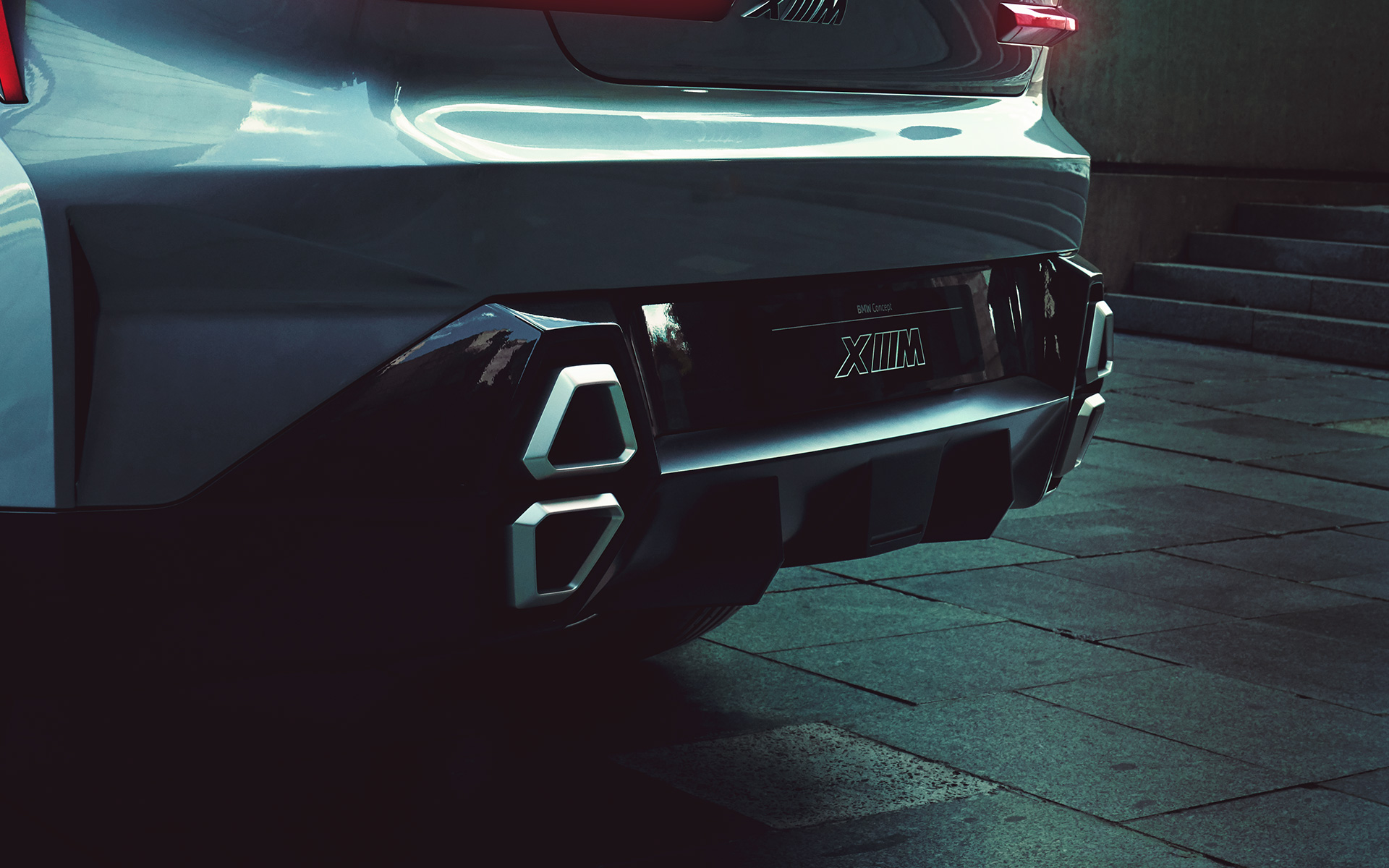 BMW Concept XM (G09) sedd snett bakifrån parkerad närbild av XM logotypen BMW Concept XM (G09) sedd snett bakifrån parkerad närbild av XM logotypen